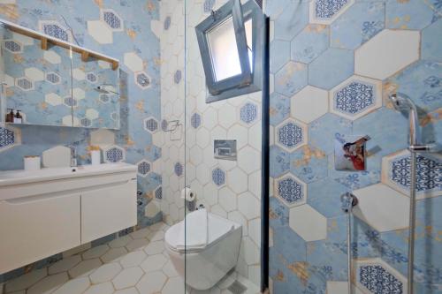 a blue and white bathroom with a toilet and a shower at Villa Vareste & Villa Taş Mahal in Fethiye