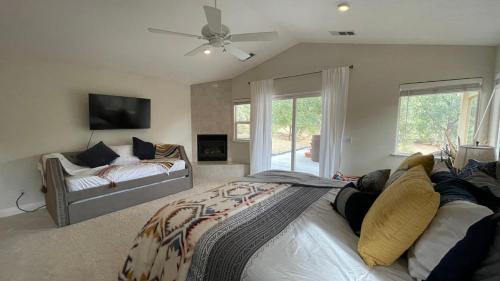 a bedroom with a bed and a couch and a fan at Mountain Haven: Wi-Fi, Luxe Views, Hot Tub close to Bass Lake, Yosemite in Oakhurst