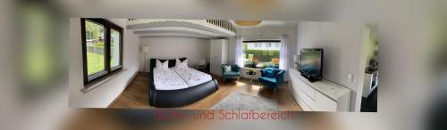 a living room with a bed and a tv at Ferienhaus Nadine 2023 komplett saniert in Bad Brambach