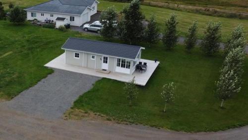 an aerial view of a white house with a car at Cosy cottage in the countryside in Þingeyjarsveit