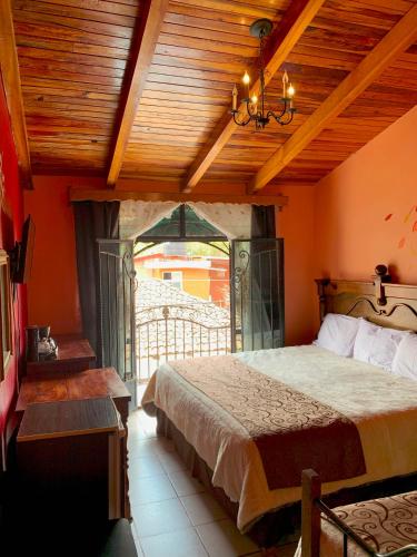 a bedroom with a bed and a wooden ceiling at Hotel Real de la Sierra in Mazamitla