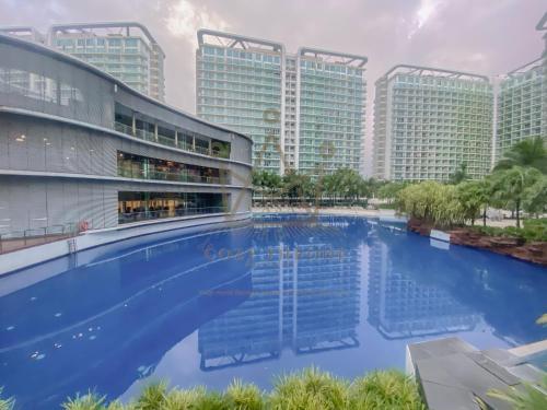 ein großer Pool mit hohen Gebäuden im Hintergrund in der Unterkunft Minimalist Luxury Condo Classic Aesthetic at Azure in Manila