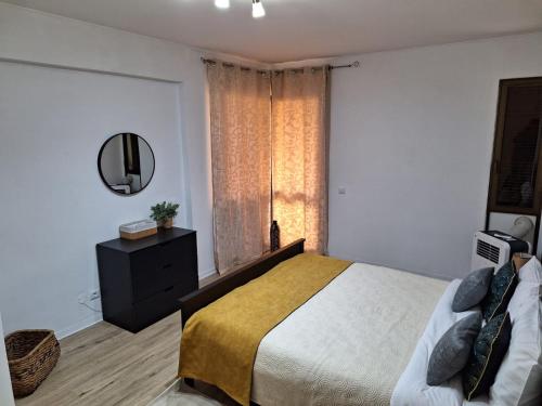 ein Schlafzimmer mit einem großen Bett und einem Spiegel in der Unterkunft Laser Pedra de Abreu in Funchal