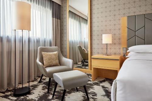 a hotel room with a bed and a chair and a desk at Sheraton Frankfurt Airport Hotel & Conference Center in Frankfurt/Main