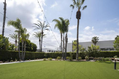 a lawn with palm trees in front of a building at Torrance Marriott Redondo Beach in Torrance