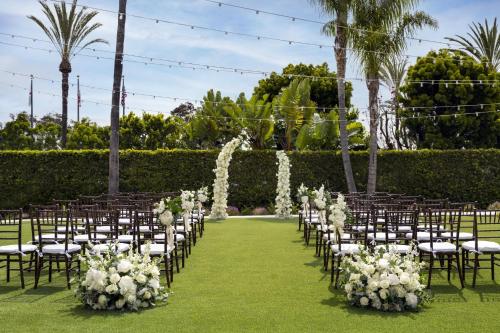 a row of chairs with white flowers on a lawn at Torrance Marriott Redondo Beach in Torrance