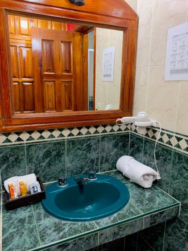 a bathroom with a blue sink and a mirror at Hotel Real de la Sierra in Mazamitla