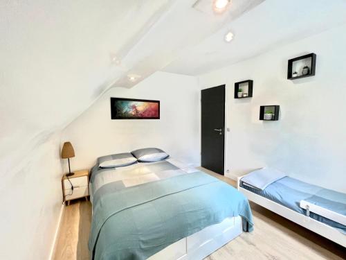 sypialnia z niebieskim łóżkiem na poddaszu w obiekcie Logement entier proche Disneyland w mieście Montry