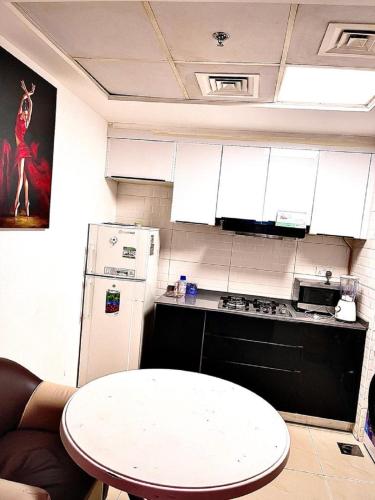 a kitchen with a white refrigerator and a table at TellaHomes in Dubai