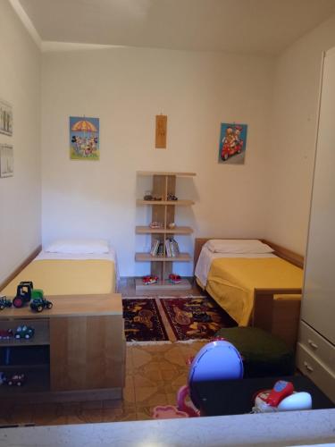a small bedroom with two beds and a shelf at Casa Belvedere a Valle San Martino di Spoleto in Spoleto