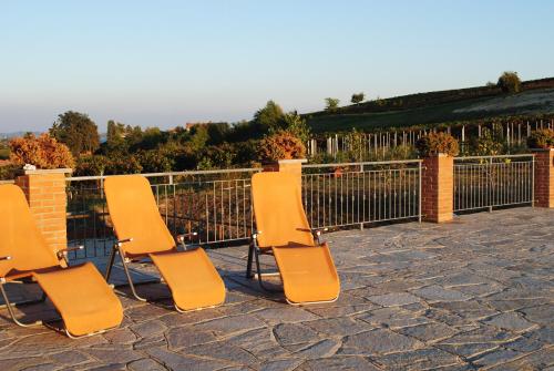 four chairs sitting on a patio next to a fence at B&B La Gibiana in Costigliole dʼAsti