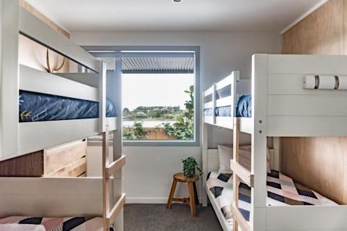 a bedroom with bunk beds and a window at Hillside Haven House & Unit in Raglan