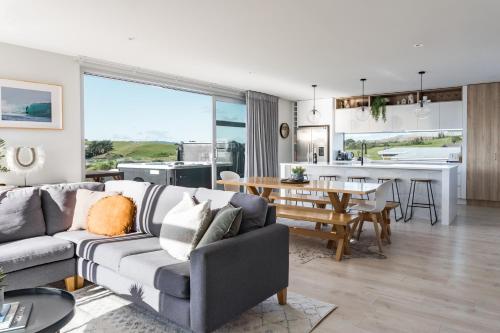a living room with a couch and a table at Hillside Haven House & Unit in Raglan