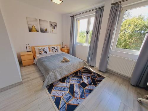 a bedroom with a bed and a large window at Limanowa Sunriser Apartment in Limanowa