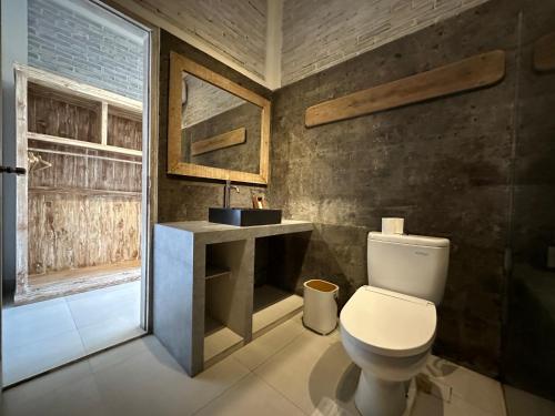 ein Bad mit einem WC, einem Waschbecken und einem Fenster in der Unterkunft Volcano Terrace Bali in Kintamani