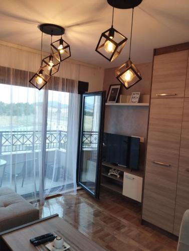 Una sala de estar con un sofá y un televisor en Green Forest Lux Apartman, en Zlatibor