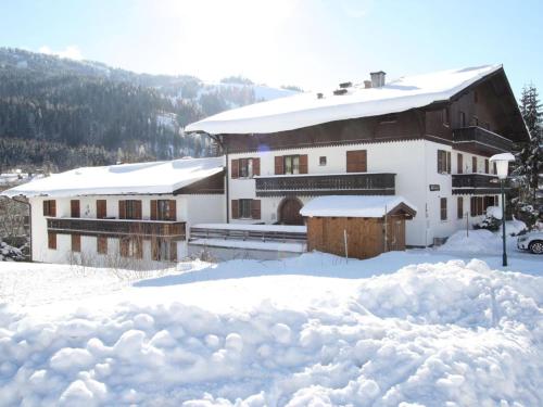 a house covered in snow with a pile of snow at Sonnleiten 15 in Maria Alm am Steinernen Meer