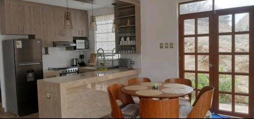 una cucina con tavolo e sedie di Casa de Campo Sarita en huanchuy condominio a Archu
