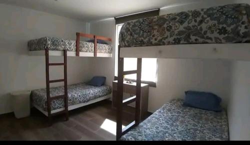 Pokój z 2 łóżkami piętrowymi i oknem w obiekcie Casa de Campo Sarita en huanchuy condominio w mieście Archu