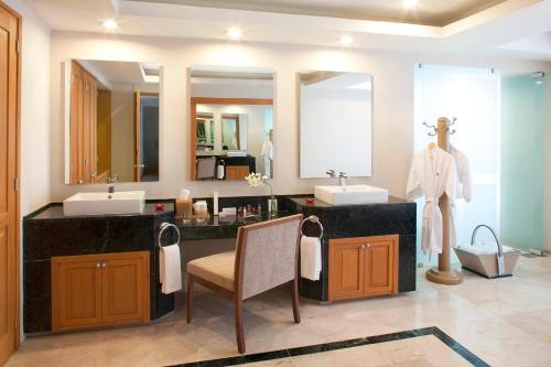 a bathroom with two sinks and two mirrors at Marriott Tuxtla Gutierrez Hotel in Tuxtla Guti&eacute;rrez