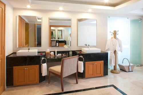 a bathroom with two sinks and two mirrors at Marriott Tuxtla Gutierrez Hotel in Tuxtla Gutiérrez