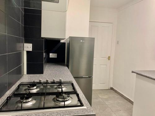 a kitchen with a stainless steel refrigerator and a stove at City Signature Apartments in Cambridge