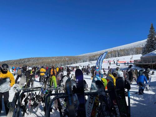 a group of people standing in the snow with their snowboards at Luxury Home Downtown NAU Route 66 Snowbowl in Flagstaff