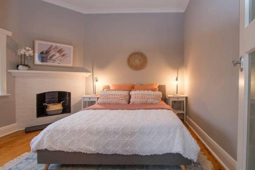 ein Schlafzimmer mit einem Bett und einem Kamin in der Unterkunft Morris Cottage Cumberland Park in Colonel Light Gardens