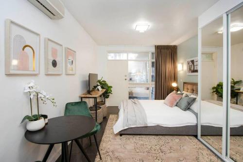 um quarto com uma cama, uma secretária e uma mesa em Boho on Sussex North Adelaide em Adelaide