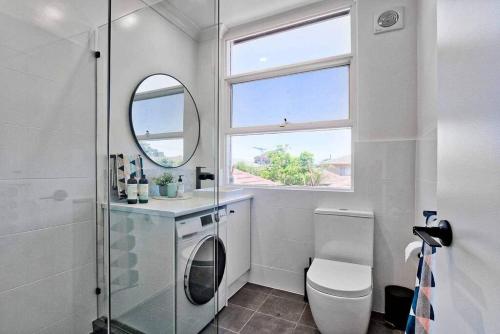 bagno con servizi igienici, lavandino e specchio di Fleur at Lotus Apartments a Plympton