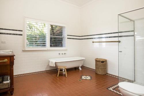 a bathroom with a tub and a sink and a window at Good Dog Hill Homestead in Bellawongarah