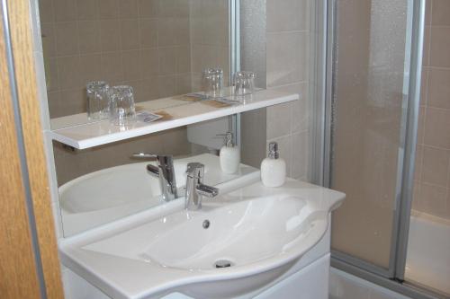 uma casa de banho com um lavatório e um chuveiro em Hotel Hölscher em Solingen