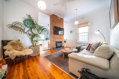 a living room with a couch and a fireplace at Il Cappano Rosa Henley Beach in Grange