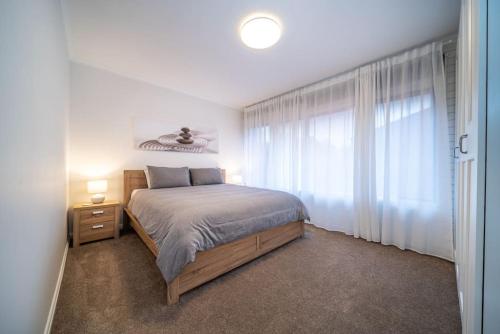 a bedroom with a bed and a large window at Emerald on Gover Street in Bowden