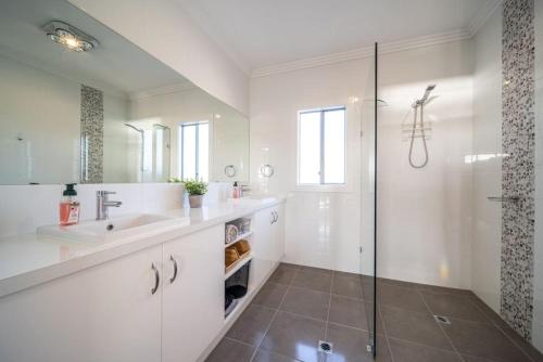 ein weißes Bad mit einem Waschbecken und einer Dusche in der Unterkunft Riverglades View Riverglades in Murray Bridge