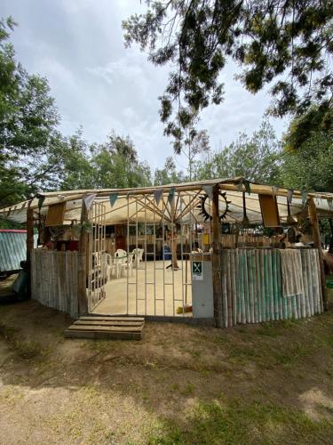 a building with a gate and tables and chairs at Mini Cabaña Roca Glamping in Suesca