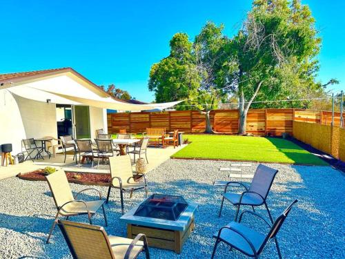 a patio with chairs and tables and a fence at Modern Home with View and Large Private backyard in San Diego