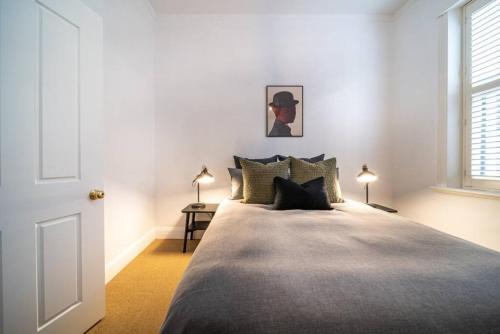 a bedroom with a large bed and two lamps at Netley Cottage Eastwood in Rose Park