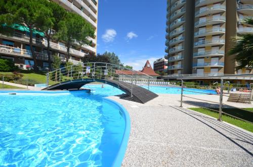 une piscine avec un pont dans un bâtiment dans l'établissement Residenza Puerto Do Sol, à Lignano Sabbiadoro