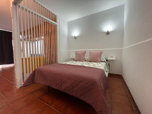 a small bedroom with a bed with two pillows at Practical and cozy apartment in southern Arona in Arona