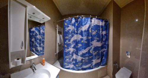 a bathroom with a sink and a blue shower curtain at Perle du Lac in Tunis