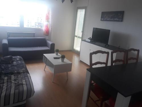 un salon avec un canapé et une table dans l'établissement appartement proche centre ville et gare, à Chalon-sur-Saône