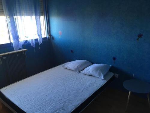 - une chambre bleue avec un lit doté de draps et d'oreillers blancs dans l'établissement appartement proche centre ville et gare, à Chalon-sur-Saône