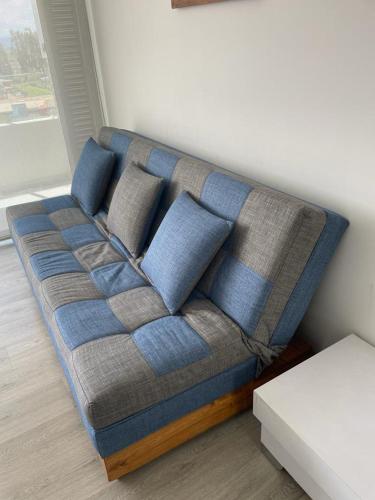 a couch with blue pillows in a living room at APARTAMENTO FAMILIAR EN PAIPA RÚSTlCO 70-9 in Paipa