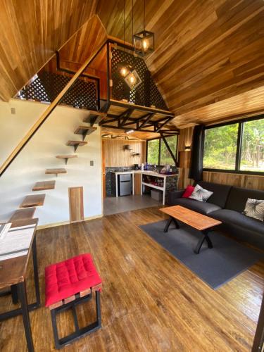 a living room with a staircase in a tiny house at Myra Chalets in Bijagua