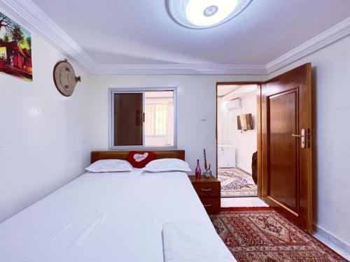 a bedroom with a white bed and a clock on the wall at RESIDENCE Kane Diallo- appartements élégants et centraux à Dakar in Dakar