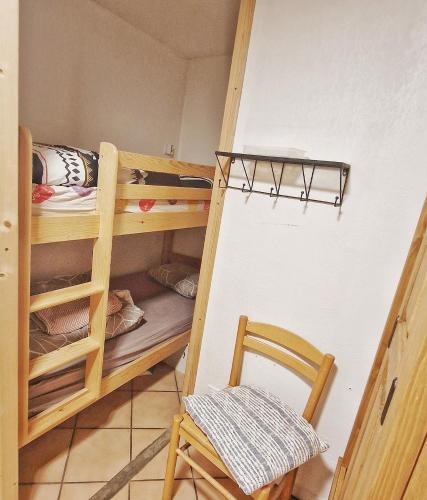 une chambre avec un lit superposé et une chaise dans l'établissement L'Oxalys Studio ! Coin montagne - Pied des pistes & Centre ville, à Briançon
