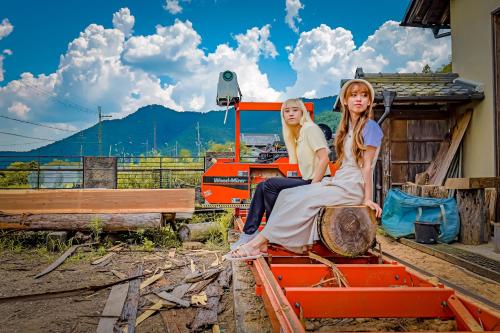 two girls sitting on an orange train at 古民家オーベルジュmocca in Kokuryō