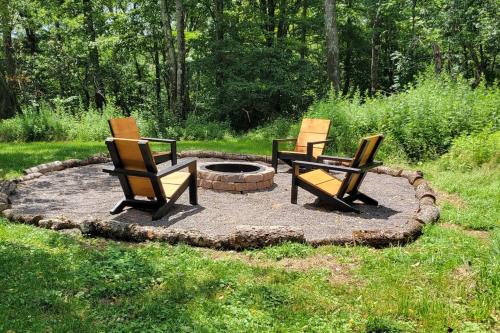 three chairs sitting around a fire pit in a yard at Bethel Woods Cabin in Mongaup Valley