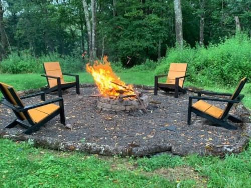 four chairs around a fire pit in a yard at Bethel Woods Cabin in Mongaup Valley